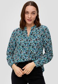 Blouse met lange mouwen met een meerkleurig abstract patroon in tinten blauw, groen en zwart, voorzien van een kraag en een knoopsluiting.