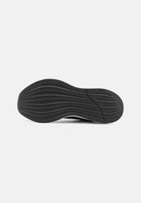 Black rubber shoe sole with a wavy tread pattern; features grooves for traction and a smooth edge.