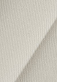 Fehér textil, sima, enyhén textúrált felülettel, szögben bemutatva, amely kiemeli a szövése mintázatát és könnyű természetét.