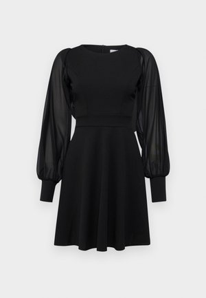 Czarna sukienka z dopasowanym gorsetem, rozkloszowanym dołem i przezroczystymi bufkami. Posiada okrągły dekolt i zamek błyskawiczny z tyłu.