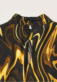 Robe en tissu noir avec un motif marbré tourbillonnant jaune et marron, col montant et fermeture par boutons à l'arrière.