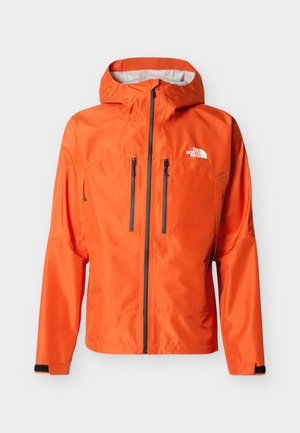 Heleoranž kapuutsiga jakk, millel on täielik must tõmblukk, kaks vertikaalset rindkere tõmblukuga taskut ning valge The North Face logo rinnal.