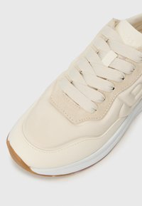 Beige sneakers med glatt skinn og semsket overdel, tonale snørebånd, gummisåle og subtile sømdetaljer. Rundet tådesign.