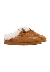 Chaussons en suède beige dotés d'une doublure en fausse fourrure blanche duveteuse, de coutures décoratives blanches, et d'une semelle brune texturée avec des lacets.