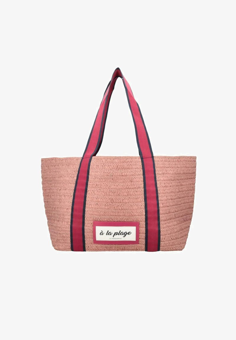 Grand sac fourre-tout en rose tissé avec des poignées rayées bleu marine et une étiquette blanche portant l'inscription "à la plage." Surface texturée avec une large ouverture.