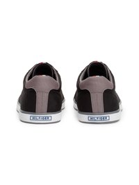 Ténis pretos em suede com detalhes cinzentos, solas de borracha brancas e um logo da marca em azul na parte traseira. Parte superior texturizada e colarinho acolchoado.