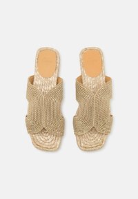 Åpen tå sandaler laget av vevd gullmateriale, med et teksturert design og kryssbåndsremmer, med en naturlig lær innersåle.