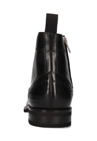 Bota negra de cuero hasta el tobillo con perforaciones decorativas, tira trasera, cremalleras laterales y tacón apilado sobre fondo blanco.