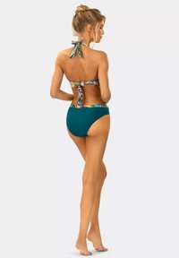 Zestaw bikini z halter topem w tropikalny wzór z wiązaniem, w połączeniu z jednolitymi, turkusowymi majtkami o wysokim stanie, wykonanymi z gładkiego materiału.
