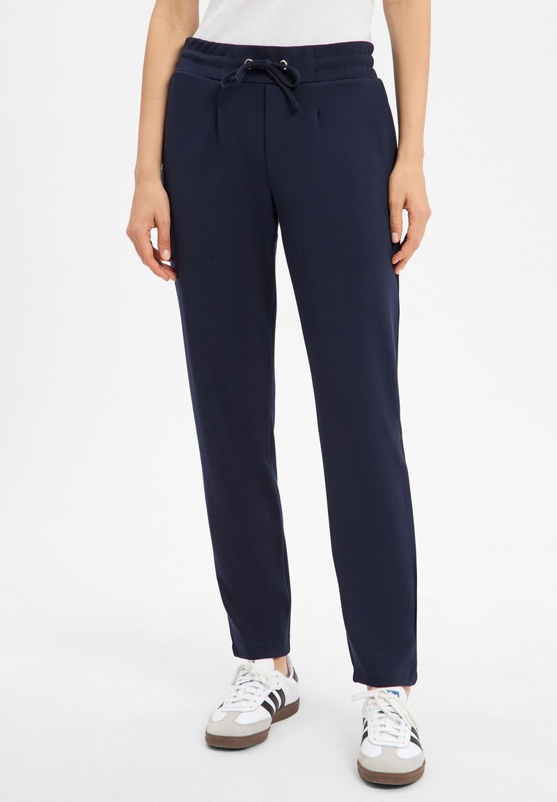 Granatowe dresy z bawełny z elastycznym paskiem w talii, sznurkiem do regulacji i bocznymi kieszeniami, z taperowanym krojem nogawek.