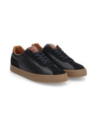 Zapatillas de cuero negro y ante con suela de goma, punta redonda y acentos marrones contrastantes en la lengüeta y el talón.