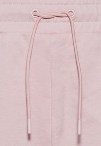 Růžové bavlněné tepláky s texturovaným povrchem, elastickým pasem a šňůrkou s plastovými konci.