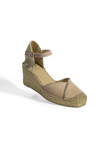Sandale compensée espadrille beige avec une bride de cheville, tige en cuir suédé, semelle en jute tressé et accents métalliques sur l'orteil et la partie supérieure.