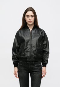 Czarna skórzana kurtka bombowiec z zamkiem błyskawicznym, �ściągaczami na mankietach i pasie. Posiada subtelne logo na piersi oraz dwie boczne kieszenie.