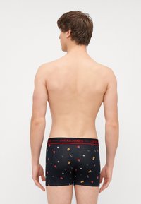 Fekete boxer alsónadrág piros derékrésszel, amelyen a "JACK & JONES" felirat szerepel. Ünnepi mintákkal díszítve, mint például hópihék és díszek.