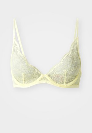 Lace bralette in pale yellow with a triangular shape, scalloped edges, adjustable straps, and a sheer texture.