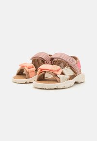 Sport sandaler med justerbara remmar i rosa och koralltoner, en texturerad sula och en lätt design med en vadderad fotbädd.
