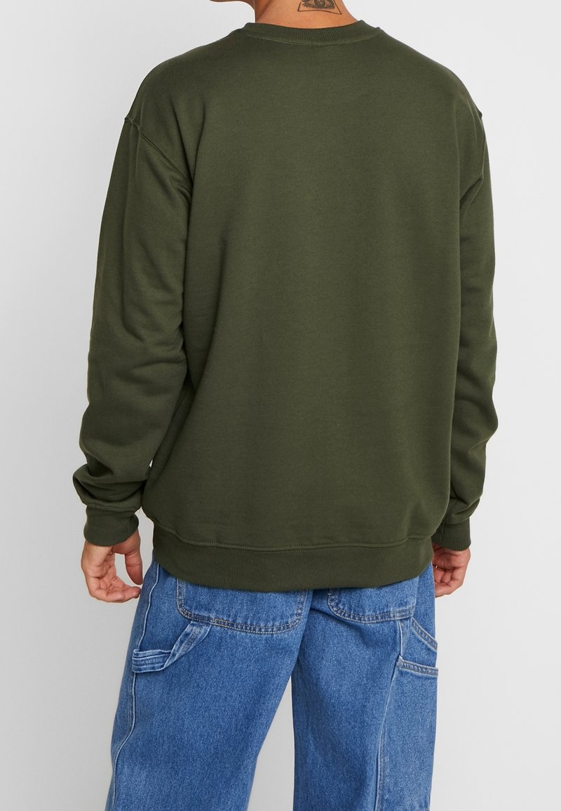 Sudadera verde oliva con cuello redondo, puños y dobladillo acanalados. Textura suave, ajuste relajado y detalle de costuras visibles en la espalda.