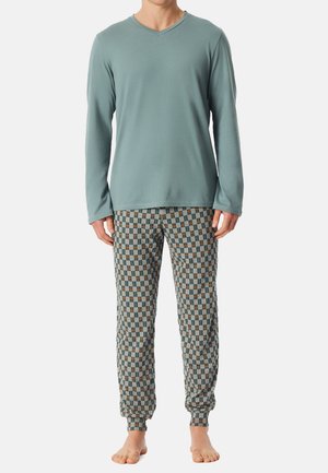 Haut gris clair à manches longues avec un col en V, associé à un pantalon de jogging à motifs avec des carrés teal, marron et crème. Poignets élastiques.