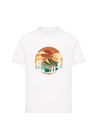 White cotton t-shirt featuring a circular graphic of mountains and trees in earthy orange, green, and white tones against a sunset background.