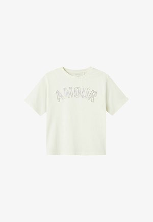 T-shirt en crème à manches courtes avec le mot "AMOUR" en lettres iridescentes. Matière en coton douce avec une coupe décontractée. Encolure ras du cou.