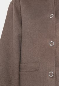 Brown wool coat with a smooth texture, featuring a small front pocket and silver circular buttons. Classic collar design with a tailored fit.