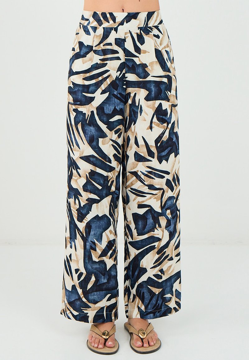 Pantalons larges en tissu léger arborant un motif abstrait dans des tons marine, beige et crème. Taille élastique pour plus de confort.