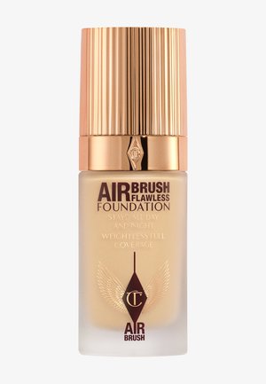 Bottiglia di fondotinta Airbrush Flawless di Charlotte Tilbury con tappo rigato dorato, fondotinta liquido beige e logo a ali su vetro smerigliato.