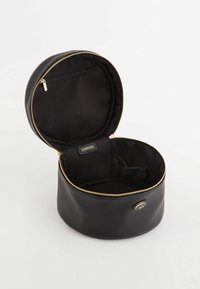 Round black cosmetic bag with a zip closure. Textured exterior, smooth interior lining, gold zipper, and a small inner pocket for organization.