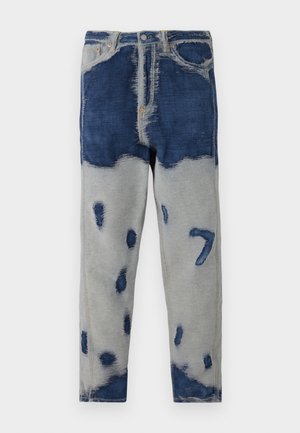 Denim jeans with a patchwork design in dark blue and grey, featuring distressed areas and fading. Includes traditional five-pocket styling.