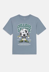 Blue T-shirt with a graphic of an anthropomorphic soccer ball wearing sneakers, with "COLLEGE LEAGUE" text above and sports-themed slogans below.