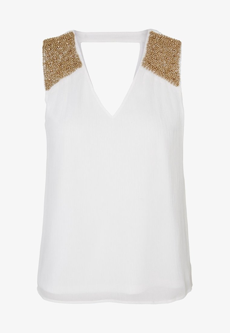 Blouse blanche sans manches à col en V avec des ornements en perles dorées sur les épaules et un tissu subtilement texturé.