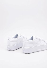 Białe platformowe sneakersy wykonane z materiału syntetycznego, z okrągłym noskiem, teksturowaną cholewką i subtelnym logo po bokach.
