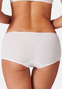 Shorts en coton blancs pour garçon, avec un design sans couture, présentant une taille douce et un minimum de finitions. Texture lisse avec une coupe classique.