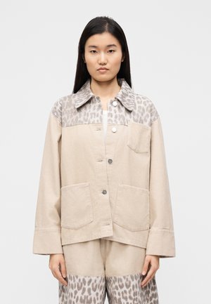 Μπεζ φόδρα από κοτλέ με γιακά σε λεοπάρ τύπωμα. Διαθέτει γιακά, δύο τσέπες με ραφή και κουμπιά. Ευθεία γραμμή με μακριά μανίκια.