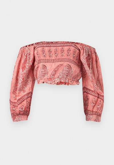 Blouse courte à épaules dénudées avec manches longues bouffantes, présentant un motif cachemire rouge et rose, avec poignets et ourlet élastiqués.