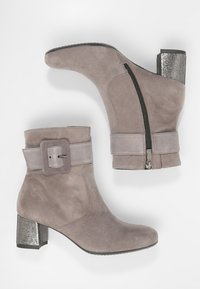 Botines de ante gris con tacón ancho, con un detalle texturizado plateado, hebilla y cremallera lateral para abrochar.