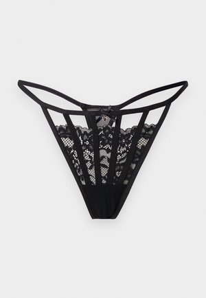 String en dentelle noire avec motif floral transparent, fines bretelles et petit nœud orné d'un charm en forme de cœur au centre devant.