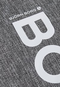 Gray textured fabric features bold white text with the brand name "BJÖRN BORG" and a stylized "W" and "O" logo.