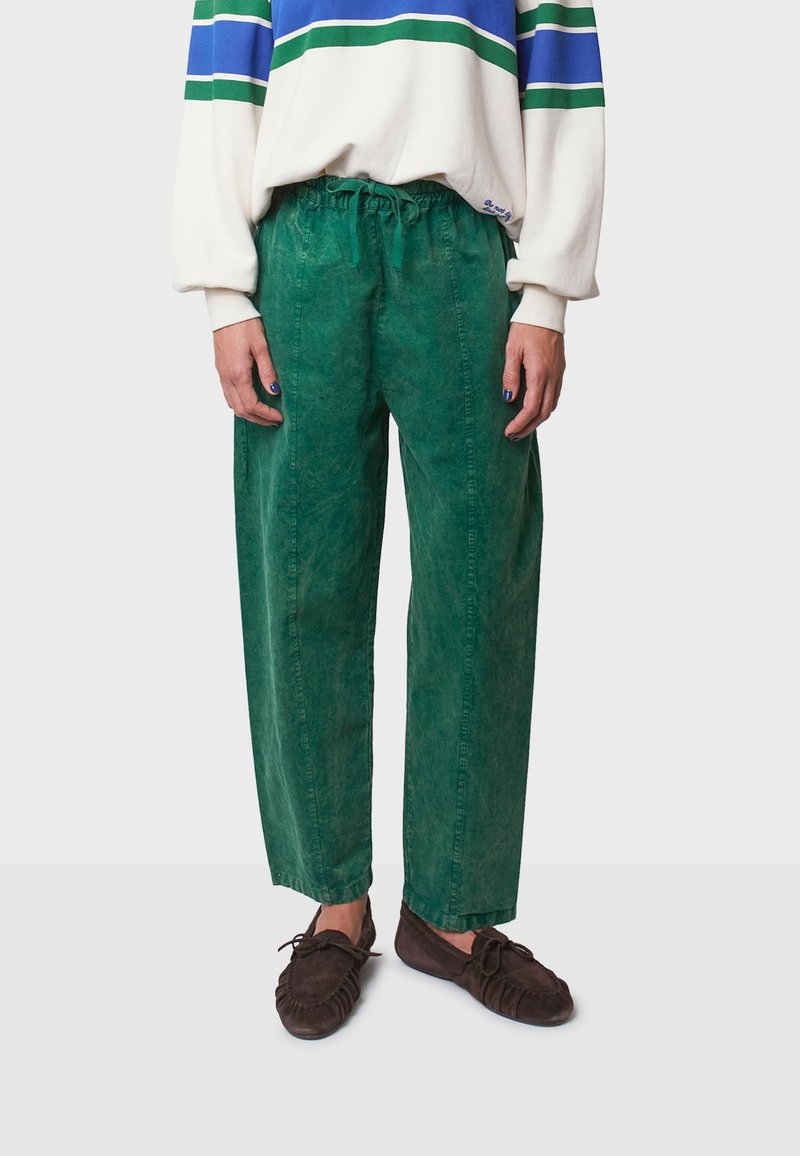 Groene katoen broek met een losse pasvorm, elastische tailleband en subtiele structuur. Gecombineerd met een witte top met blauwe en groene strepen.