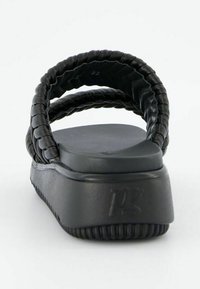 Sandales noires à glissière avec des sangles tressées, une semelle plate et une plate-forme légèrement surélevée avec un détail en caoutchouc texturé.
