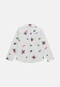 Witte blouse met knopen, versierd met een mix van kleurrijke geborduurde patronen, waaronder tekst, pijlen en cartoonfiguren op de achterkant.