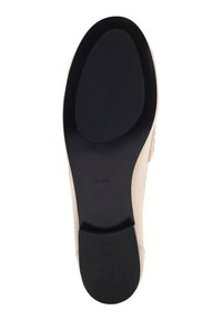 Beige sko med en slät, texturerad ovandel och en svart gummisula med en lätt kurva, utformad för stabilitet och komfort.