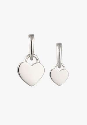 Zwei silberne, herzförmige Vorhängeschloss-Anhänger in verschiedenen Größen, die an glatten Haken vor weißem Hintergrund hängen.
