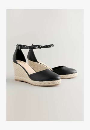 Mustad musta värvi espadrillid tekstuurse nahkatekkega, jute-kattega platvorm, pahkluu rihm hõbedaste nukkidega, ümar varvas.