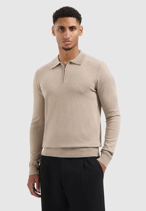 Beige knit pullover with a half-zip collar, long sleeves, and a fitted hem. Made from soft fabric, featuring a smooth texture.