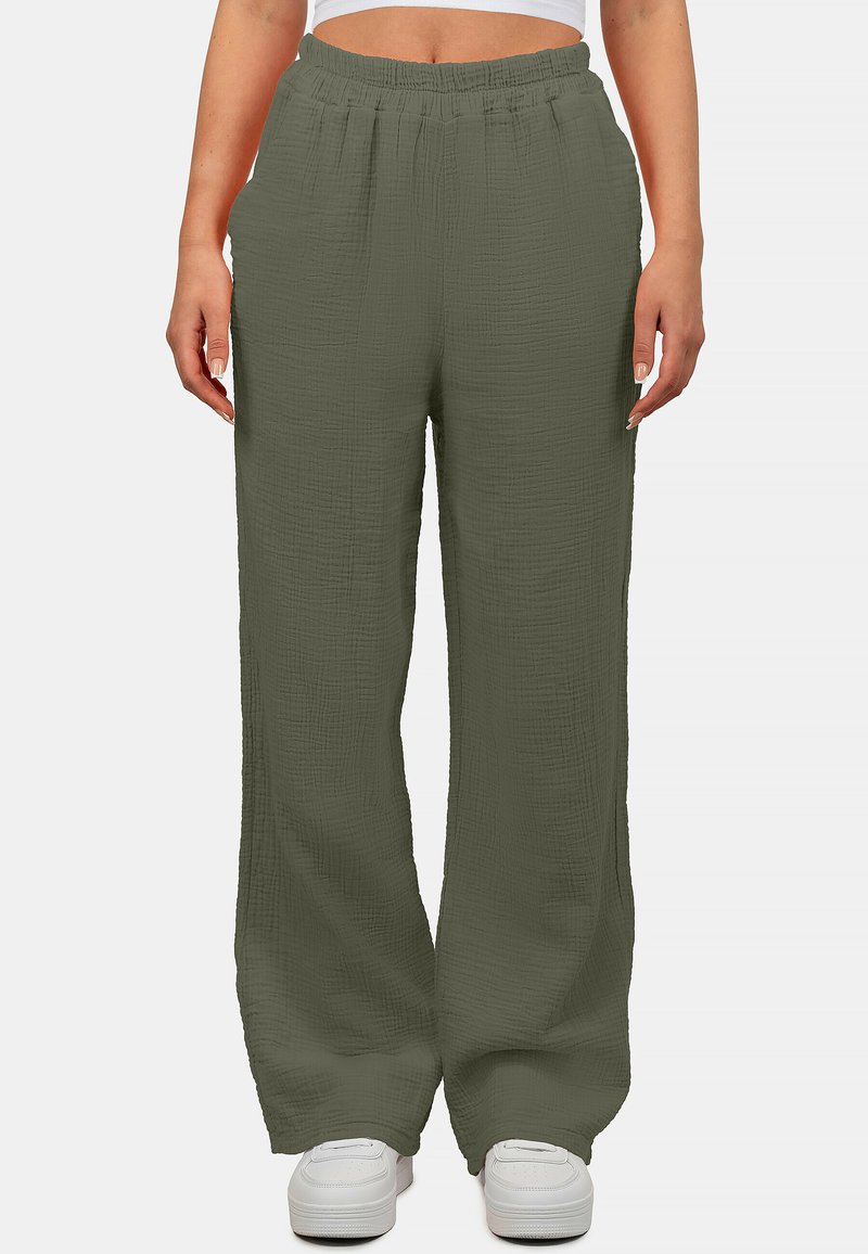 Losse, olijfgroene broek van textiel met een elastische tailleband; beschikt over twee zijzakken en een rechte pijpdesign.