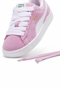 Baskets en suède rose clair avec des lacets blancs, une semelle en caoutchouc texturée et une bande d'accent blanche. Comprend une paire supplémentaire de lacets roses.