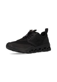 Scarpa da ginnastica nera con tomaia in rete, sovrapposizioni testurizzate e una suola spessa segmentata con ritagli triangolari per la ventilazione.