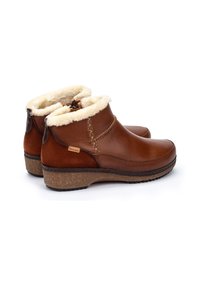 Botas de tobillo de cuero marrón con forro de pelaje sintético, puntera redondeada, costuras decorativas y suela de corcho de goma para mayor tracción.